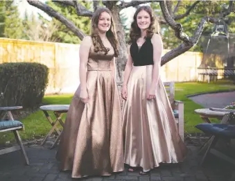  ?? GAVIN YOUNG ?? Twin sisters Jane and Claire Hopkins wore their grad dresses in their Calgary backyard recently. They are graduating from Henry Wise Wood High School this year but there will be no regular ceremonies.