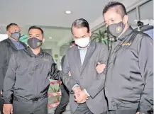  ?? - Bernama photo ?? Nizam Sahari (centre) being escorted by MACC personnel at the Sessions Court lobby yesterday in Shah Alam.