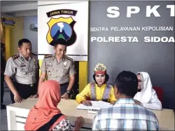  ?? EDI SUDRAJAT/JAWA POS ?? LEBIH RAMAH: Kapolresta Sidoarjo Kombespol Muhammad Anwar Nasir (dua dari kiri) mengecek pelayanan masyarakat oleh polwan yang berpakaian adat di gedung SPKT kemarin.