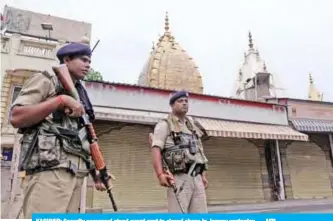  ?? — AFP ?? KASHMIR: Security personnel stand guard next to closed shops in Jammu yesterday.