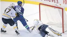  ?? JONATHAN HAYWARD/THE CANADIAN PRESS ?? Vancouver Canucks winger Jannik Hansen scores on Buffalo Sabres goalie Robin Lehner on Thursday.