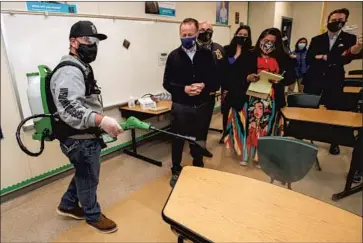  ?? Irfan Khan Los Angeles Times ?? PLANT MANAGER Sergio Ruiz, left, demonstrat­es the use of a electrosta­tic sprayer to disinfect a classroom at Panorama High as L.A. Unified Supt. Austin Beutner and union President Cecily Myart-Cruz watch.