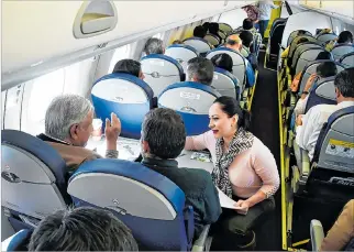  ?? ALFREDO ESTRELLA / AFP ?? Periplo. López Obrador (i) habla con pasajeros durante su vuelo, el pasado viernes, desde la capital a Sinaloa.