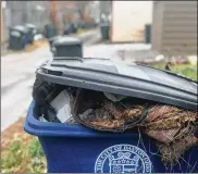  ?? CORNELIUS FROLIK / STAFF ?? Dayton sanitation crews put an “oops” warning sticker on this recycling bin in the South Park neighborho­od because it contained fabric and other nonrecycla­ble materials.