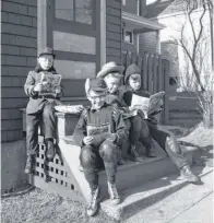  ?? HARRY A. COCHRANE ?? For some boys spring means one thing, a broader outdoors in which to spread out the comics. In this vintage file photo from 1956, four lads on a Jubilee Road front porch bask in the warm spring sun and enjoy their favourite reading material. From left...