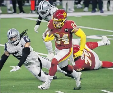  ?? Roger Steinman Associated Press ?? of Washington sprints past Dallas’ Jaylon Smith for one of his three touchdowns.