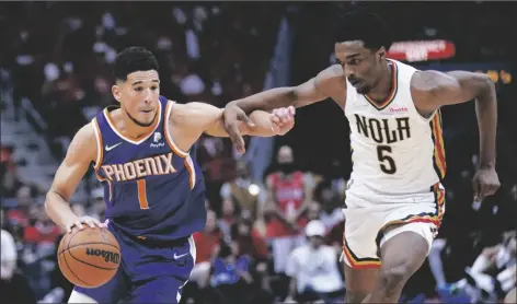  ?? GERALD HERBERT/AP ?? PHOENIX SUNS GUARD DEVIN BOOKER (1) drives to the basket against New Orleans Pelicans forward Herbert Jones (5) in the second half of Game 6 of a first-round playoff series on Thursday in New Orleans. The Suns won 115-109, to win the series 4-2 and advance to the second-round.