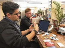  ?? JAMES ANDERSON / AP ?? Software engineer David Viramontes (front) and digital strategist Patrick Collins direct a meeting of Code For Denver, where IT profession­als offer their expertise on projects.