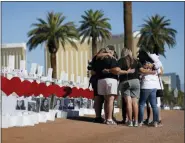  ?? JOHN LOCHER - THE ASSOCIATED PRESS ?? People pray at a makeshift memorial for shooting victims, Oct. 1, in Las Vegas, on the anniversar­y of the mass shooting two years earlier.