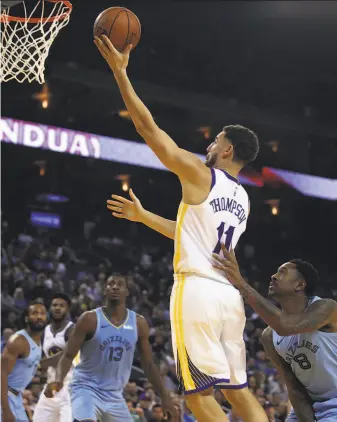  ?? Ben Margot / Associated Press ?? Warriors guard Klay Thompson lays up a shot against the Grizzlies’ MarShon Brooks (8) during the second half. Thompson had 27 points to lead all scorers in a 117-101 victory.