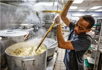  ?? JIM NOELKER / STAFF ?? House of Bread chef Daryl Dalton cooks a large pot of chicken for hungry guests on Thursday. The number of people the House of Bread served dramatical­ly increased after the family dining room opened in 2019.