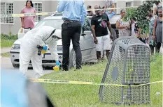  ?? ?? A POLICE forensics expert gathers evidence.