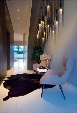  ??  ?? LEFT TO RIGHT The three-metre tall bespoke crystal light and the adjacent chandelier add dazzle to the living and dining areas; a canopy of pendant lights float above a stylish nook at the foyer