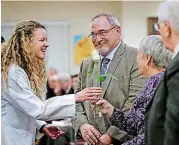  ??  ?? Kaily Cox presents Barbara Vauken and Brian Buswell with a rose Nov. 14 during the Anatomical Donor Service of Appreciati­on and Remembranc­e at the University of Oklahoma College of Medicine in Oklahoma City.