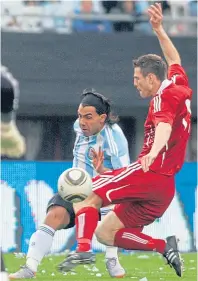  ??  ?? Richard Hastings takes on Carlos Tevez of Argentina