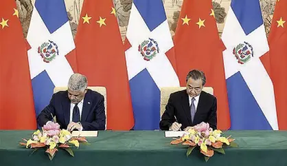  ?? XINHUA/DING LIN ?? Chinese State Councilor and Foreign Minister Wang Yi (right) and Dominican Foreign Minister Miguel Vargas sign a joint communique on the establishm­ent of diplomatic relations in Beijing, capital of China, May 1, 2018.