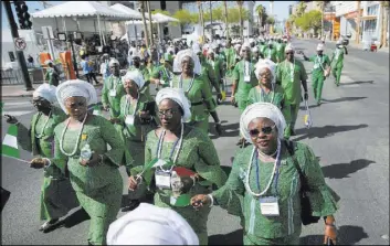  ?? Erik Verduzco Las Vegas Review-Journal @Erik_Verduzco ?? People holding Nigerian flags participat­e Saturday in the Lions Clubs Internatio­nal Parade of Nations on Fourth Street in Las Vegas.