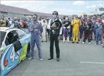  ?? John Bazemore Associated Press ?? THE SHOW OF SUPPORT for Bubba Wallace, left, standing next to Richard Petty, right, was strong before Monday’s NASCAR race in Talladega, Ala. But the sport must address its Confederat­e f lag issue better.