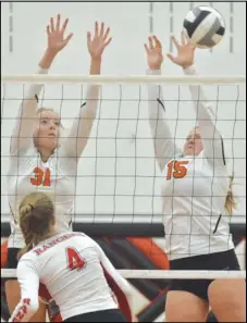  ?? Staff photo/Jake Dowling ?? Minster’s Brynn Oldiges (31) and Alyssa Niemeyer (15) block New Knoxville’s Avery Henschen’s block over the net during Tuesday’s match.