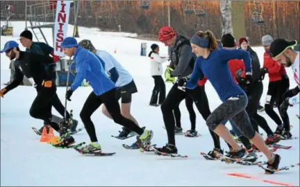  ?? MARIAN DENNIS — DIGITAL FIRST MEDIA ?? Runners in snow shoes began their challengin­g journey up the slopes at Spring Mountain Adventures Saturday during the annual Snowshoe Race. Racers took a path up and across the slope before returning back down to the finish line.
