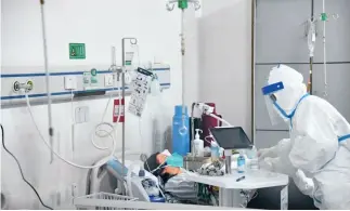  ??  ?? Una médica trata a una paciente en el Hospital Unión Afiliado al Colegio Médico Tongji de la Universida­d de Ciencia y Tecnología de Huazhong, durante la lucha contra el COVID-19.