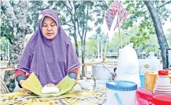  ?? MARK PERANDOS ?? HOW TO. A Tausug woman shows how she prepares pastil that she sells at the Kadayawan Tribal Village in Magsaysay Park.