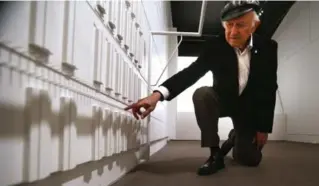  ??  ?? Auschwitz survivor Nate Leipciger points to his barracks. The Evidence Room is an examinatio­n of the role architectu­re played in constructi­ng Auschwitz.