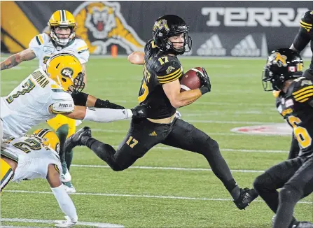  ?? JOHN RENNISON THE HAMILTON SPECTATOR ?? Ticats receiver Luke Tasker, centre, shakes Edmonton defenders as he heads to the end zone for the touchdown that cut the Eskimos’ lead to 24-22.