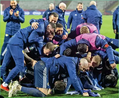  ??  ?? PILE-UP: Palmer and the rest of the Scotland squad celebrate the historic shoot-out win over Serbia in Belgrade