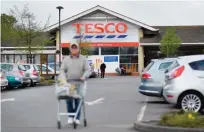  ??  ?? LONDON: A customer pushes a shopping trolley as he walks through the car park of a Tesco store in Sevenoaks, south-east of London yesterday. Supermarke­t giant Tesco revealed yesterday that it fell into an annual net loss of £40 million due to a costly...