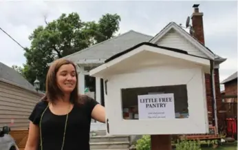  ?? ALEX MCKEEN/TORONTO STAR ?? Melissa Castanheir­a shows off her “Little Free Pantry,” which she recently installed outside her Humewood home.