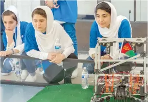  ?? — AFP ?? Members of the Afghan all-girls robotics team, with their robot nearby, watch other country’s robots in the practice area between 2017 FIRST Global Challenge competitio­ns, in Washington, DC.