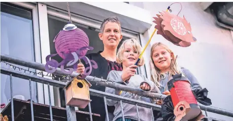  ?? RP-FOTO: ANNE ORTHEN ?? Birgit Esch aus Heerdt singt mit ihren Töchtern Lotta (7) und Frida (10) auf dem Balkon Martinslie­der.