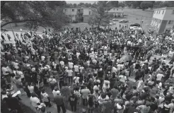  ?? — AP ?? Hundreds of people gather at the Canfield Green apartments for a prayer around the memorial to Michael Brown, an unarmed black 18- year- old who was fatally shot by a white police officer three weeks earlier, during a rally in Ferguson, Missouri, on...