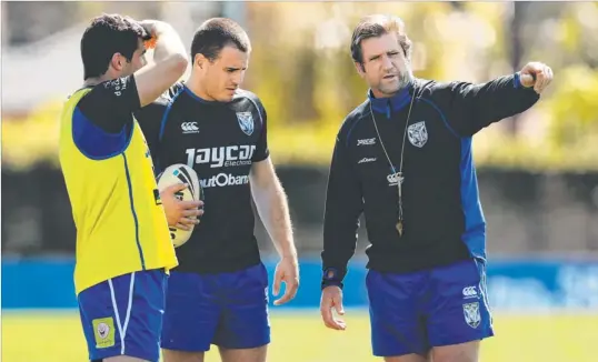  ??  ?? Bulldogs coach Des Hasler (right) chats with skipper Michael Ennis and playmaker Josh Reynolds at training yesterday.
Photo: BRETT COSTELLO