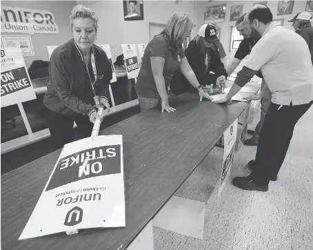  ?? DAN JANISSE ?? Beth Adams, left, and Local 444 colleagues prepare strike signs Wednesday for Caesars Windsor employees at the union hall.