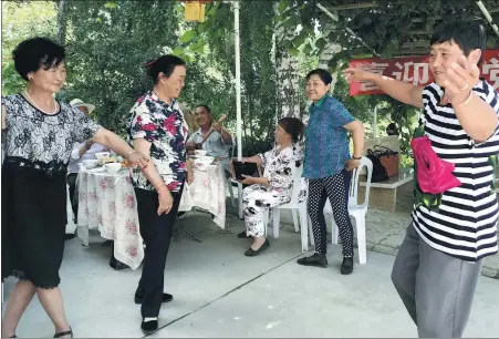  ?? PROVIDED TO CHINA DAILY ?? Descendant­s of the Huerjia, a group of Han people who arrived in Hongdun, Xinjiang Uygur autonomous region, in the 1860s, perform a folk dance with neighbors from other ethnic groups in a garden.