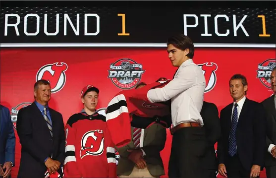  ?? NAM Y. HUH/The Canadian Press ?? Centre Nico Hischier, chosen by the New Jersey Devils in the first round of the NHL hockey draft, puts on a jersey Friday in Chicago.