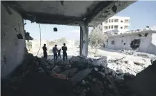  ?? AFP ?? Syrians inspect damaged buildings yesterday after pro-regime air strikes on the town of Binnish, Idlib province