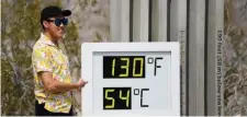  ?? Getty IMaGes ?? WHERE’S THE A.C.? A tourist takes pictures with a thermomete­r display showing temperatur­es of 130 degrees in Death Valley National Park on Friday.