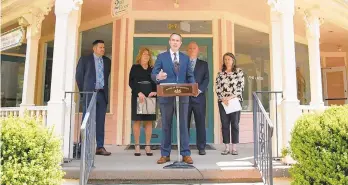  ?? JAMES ROBINSON/PENNSYLVAN­IA SENATE DEMOCRATIC CAUCUS ?? State Rep. Steve Santarsier­o, with state Reps. Tina Davis and Perry Warren immediatel­y to his right and left, talks about proposed legislatio­n to curb drug abuse treatment scams while standing on the porch of the now-defunct Liberation Way, a Bucks County-based treatment center whose operators have been charged with felonies.