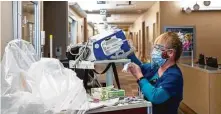  ?? Godofredo A. Vásquez / Staff photograph­er ?? Registered nurse Doris Hunter gets a crash cart as medical staff care for a patient at Houston Methodist last week.