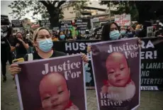  ??  ?? Protesters hold placards calling for justice outside the Manila North Cemetery where Nasino attended River’s burial.