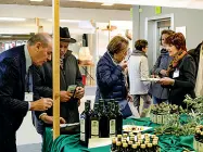  ??  ?? Tipicità Alcuni ospiti degustano olio biologico e visitano gli stand della Fiera d’Autunno