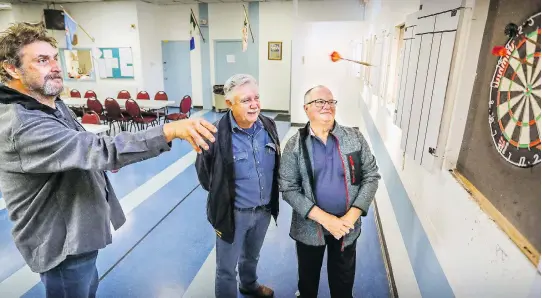  ?? JOHN MAHONEY ?? Comedian Joey Elias, left, plays darts with Royal Canadian Legion 212 president Ray Comrie and first vice-president Bruce Allan. The legion is facing foreclosur­e.