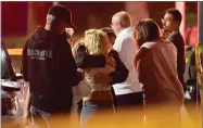  ?? AP FILE PHOTO BY MARK J. TERRILL ?? In this Nov. 8, photo, people comfort each other as they stand near the scene in Thousand Oaks, Calif., where a gunman opened fire inside a country dance bar crowded with hundreds of people.