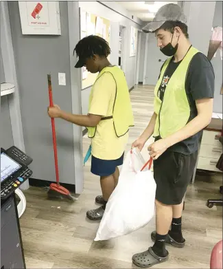  ?? Katie West • Times-Herald ?? Camron Broomfield, left, and Kyle Williams, clean up the Forrest City Police Department building. The youth are two of many local youth who are participat­ing in this year’s Youth Employment Project.