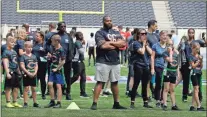  ?? Ap-frank Augstein ?? NFL Player Akiem Hicks of the Chicago Bears coaches a young team during the final tournament for the UK’S NFL Flag Championsh­ip, featuring qualifying teams from around the country, at the Tottenham Hotspur Stadium in London on July 3.