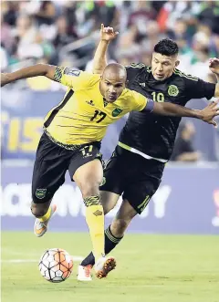  ??  ?? Jamaica’s Rudolph Austin (left) battles with Mexico’s Oribe Peralta during the first half of the CONCACAF Gold Cup championsh­ip match on Sunday, July 26, 2015, in Philadelph­ia.