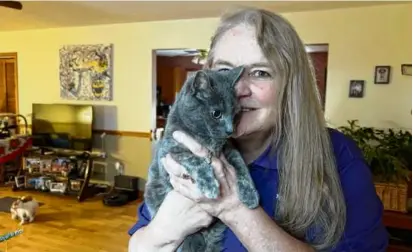  ?? PATRICK ORSAGOS/ASSOCIATED PRESS ?? Juanita Mengel held her cat, Lola-Pearl, at home in Amanda, Ohio, earlier this month. The duo is one of an estimated 200 therapy cat teams registered in the US through Pet Partners.